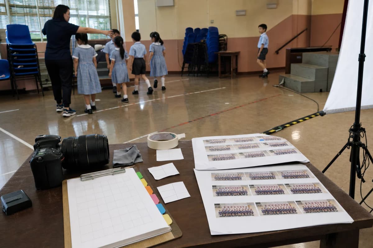 Teacher checking class photo arrangements against a class and student roster