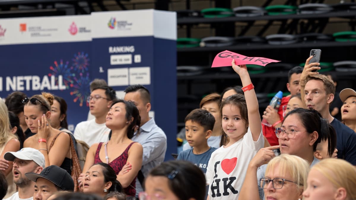 Supporters raise a sign while watching the Asian Netball Championships