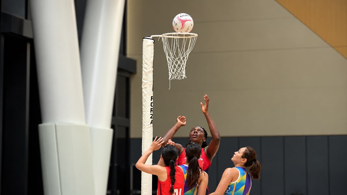 Players contest a shot beneath the netball post at the Asian Netball Championships