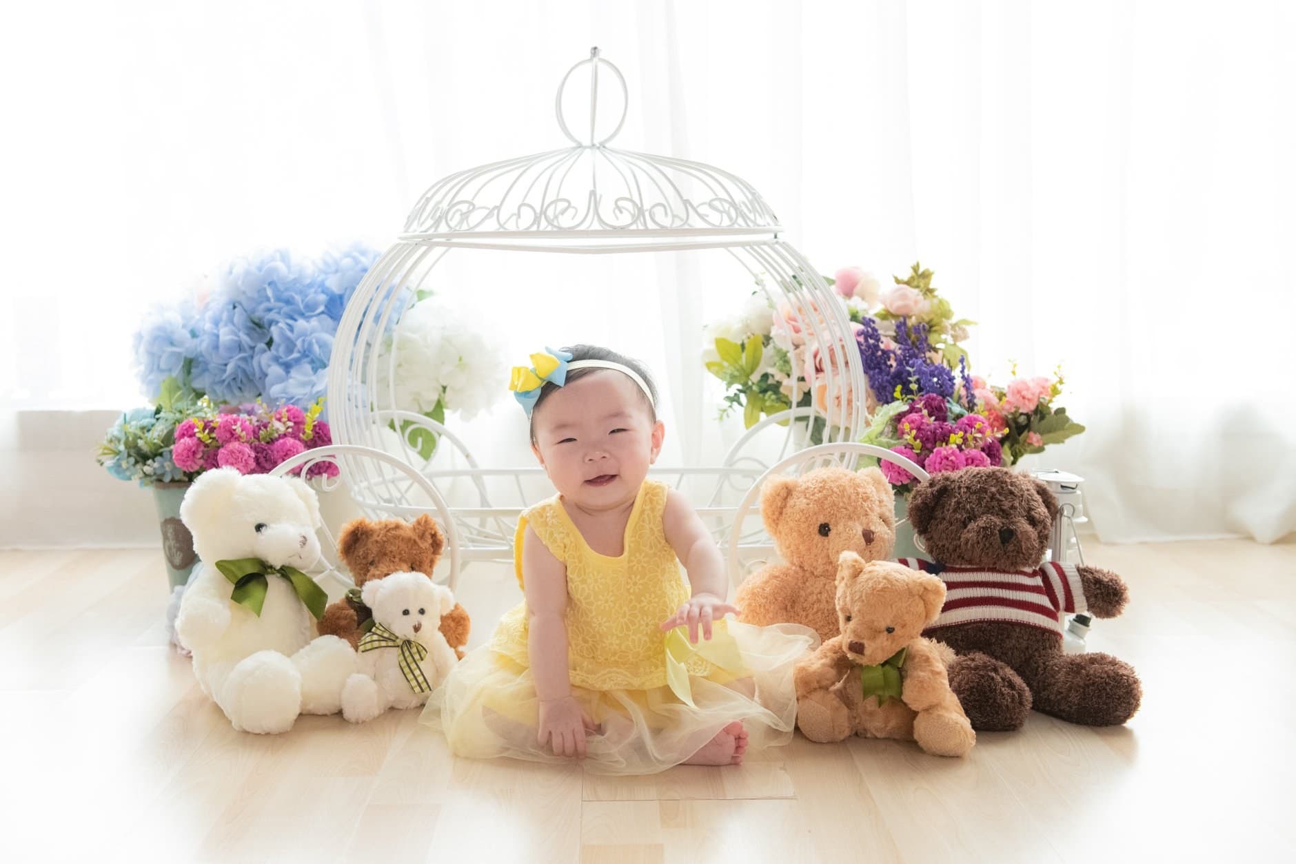寶寶坐在白色鳥籠與毛公仔旁的 Baby Session 場景