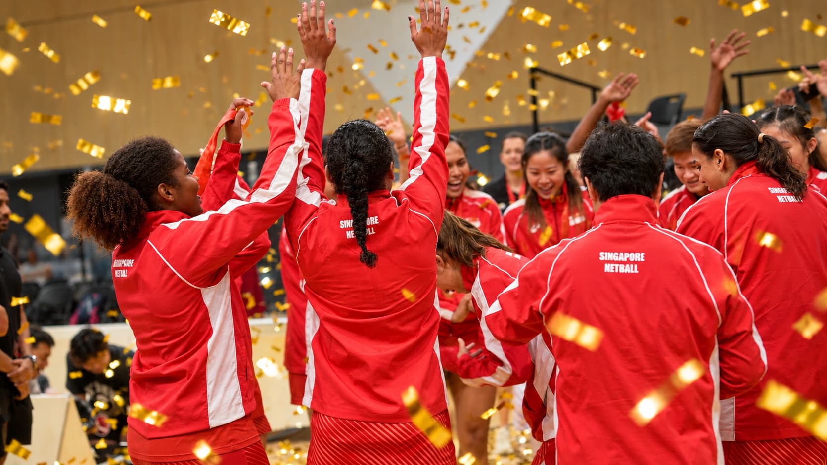 A team celebrates beneath gold confetti after the Asian Netball Championships presentation