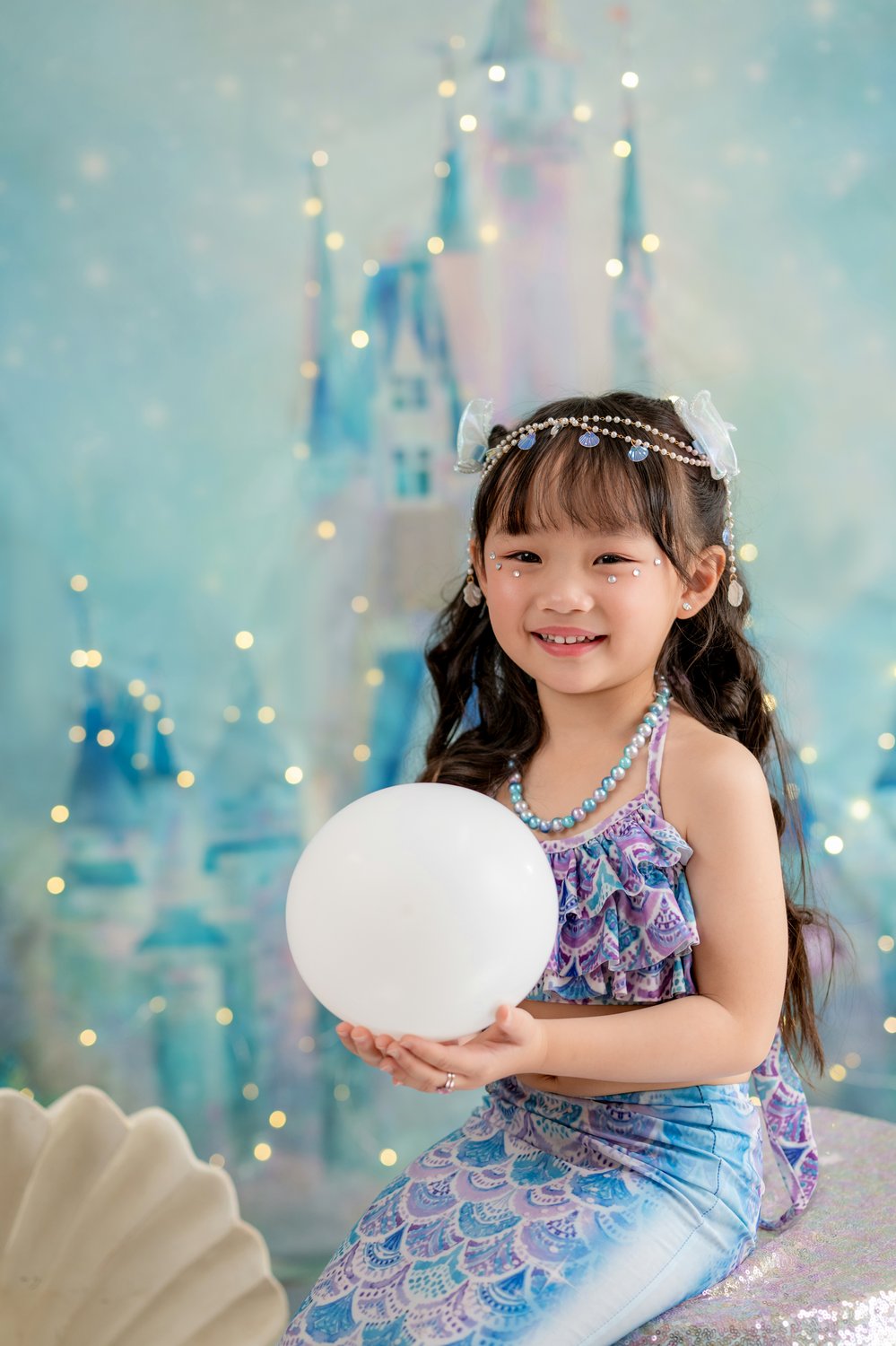 Mermaid princess holding glowing pearl underwater castle