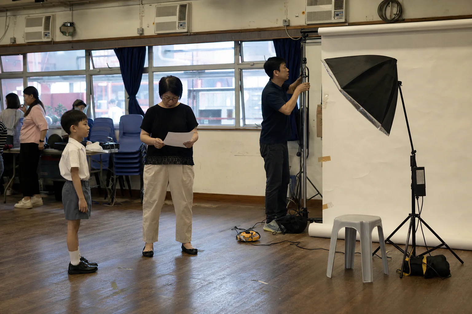 Teacher checking an on-site student ID portrait station against school requirements
