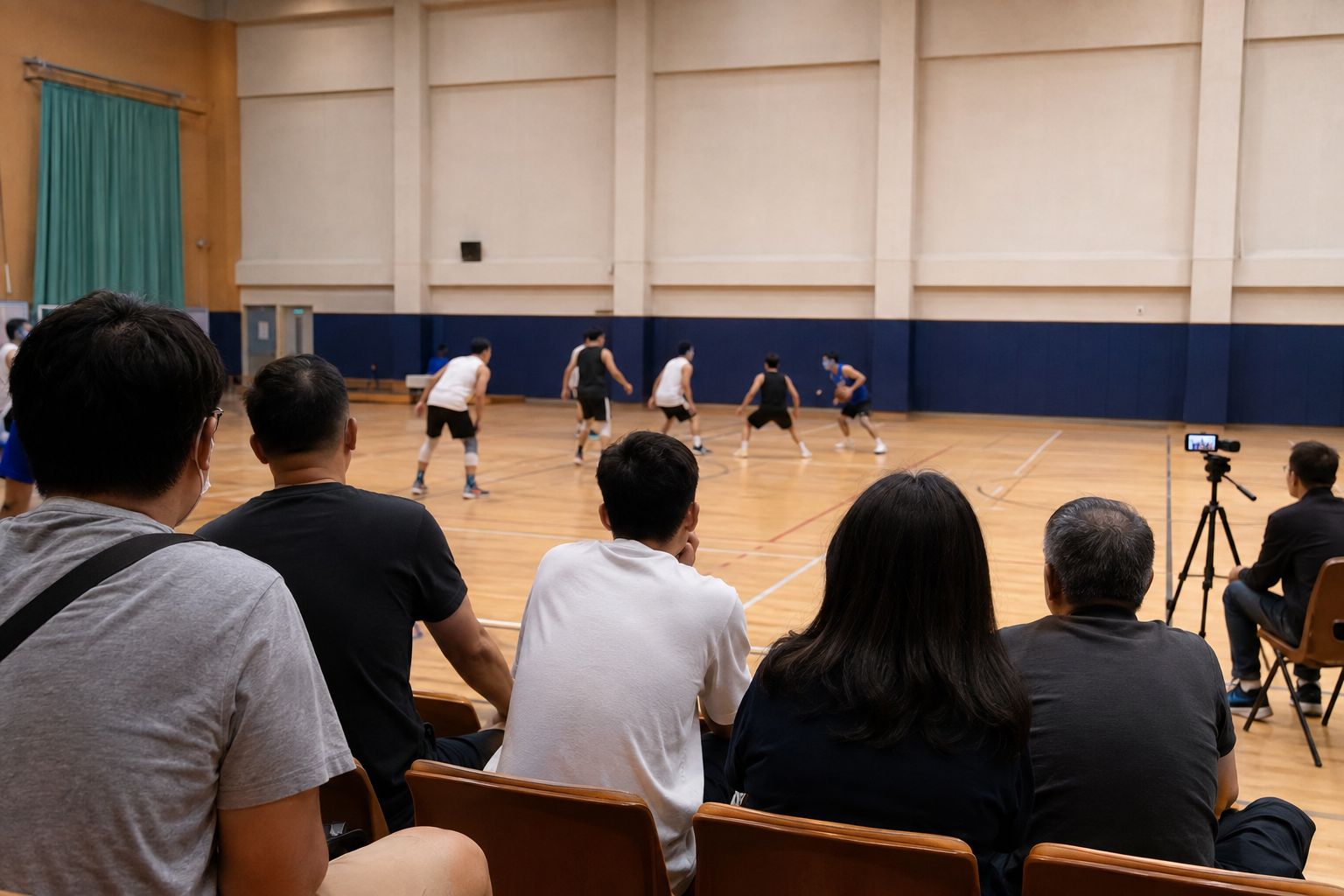 Spectators watch an indoor sports match with a camera at the sideline
