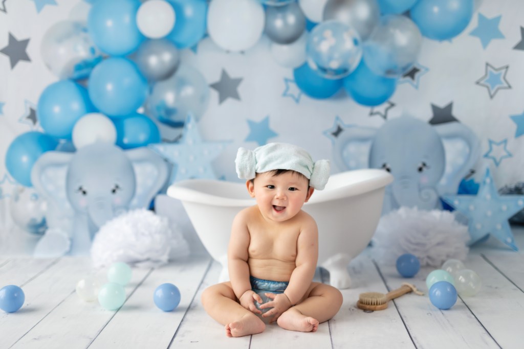 Baby smashing cake during first birthday Cake Smash photo session